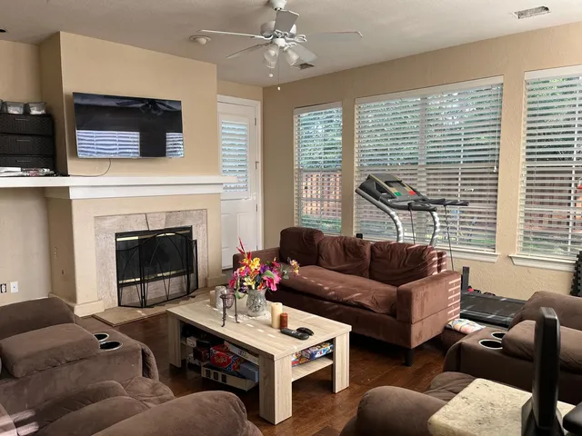 a living room with furniture a large window and a fireplace