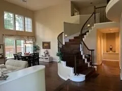 a living room with fireplace furniture wooden floor and a large window