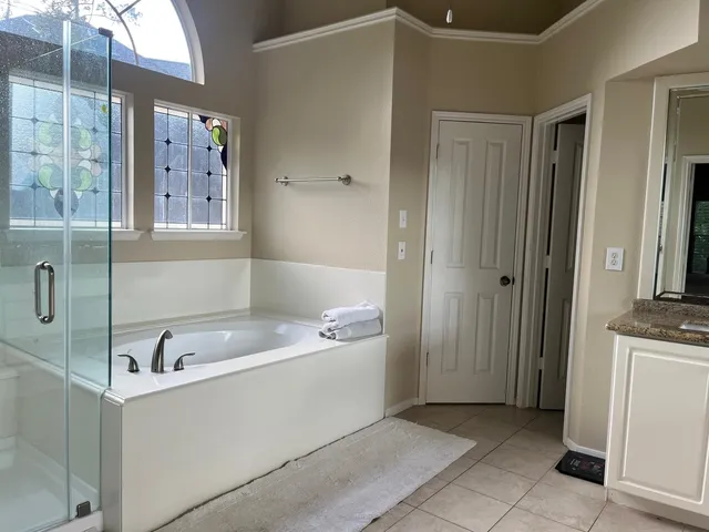 a bathroom with a tub sink and mirror