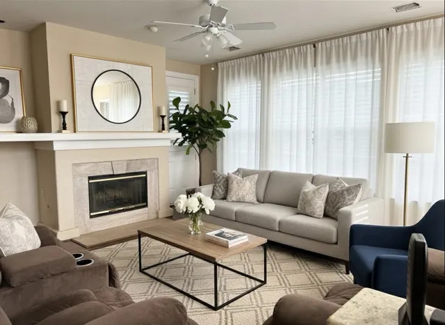 a living room with furniture a large window and a fireplace