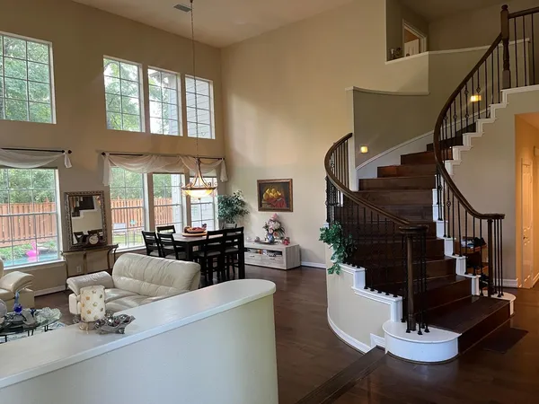 a living room with fireplace furniture dining table and a large window