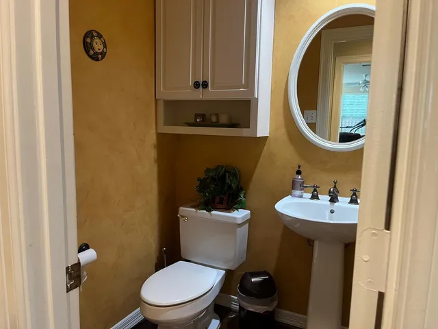 a bathroom with a toilet a sink and mirror