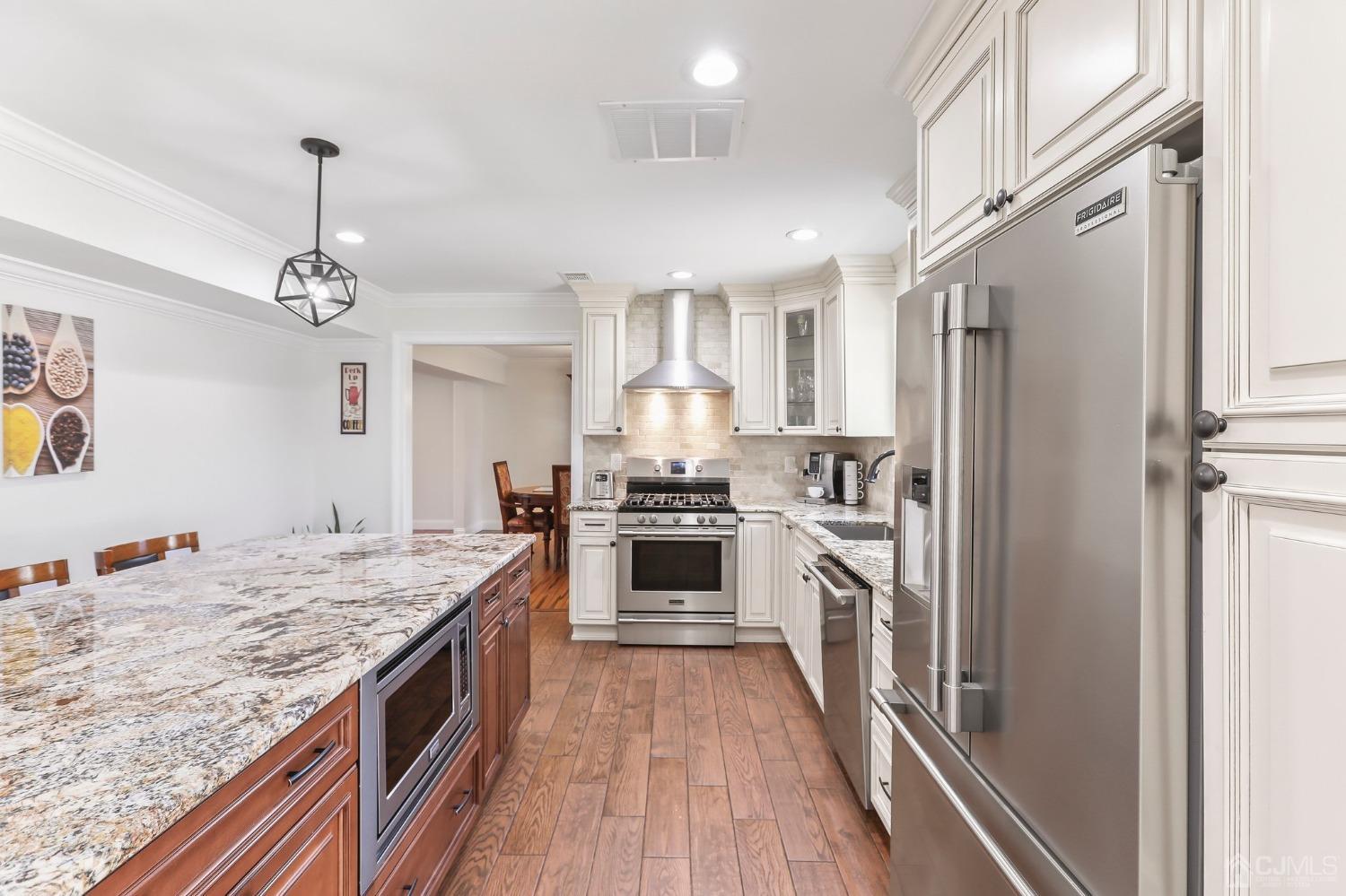 7 Mountbatten Drive Old Bridge, NJ 08857 - Photo 16 of 42 a kitchen with a center island wooden floor and stainless steel appliances