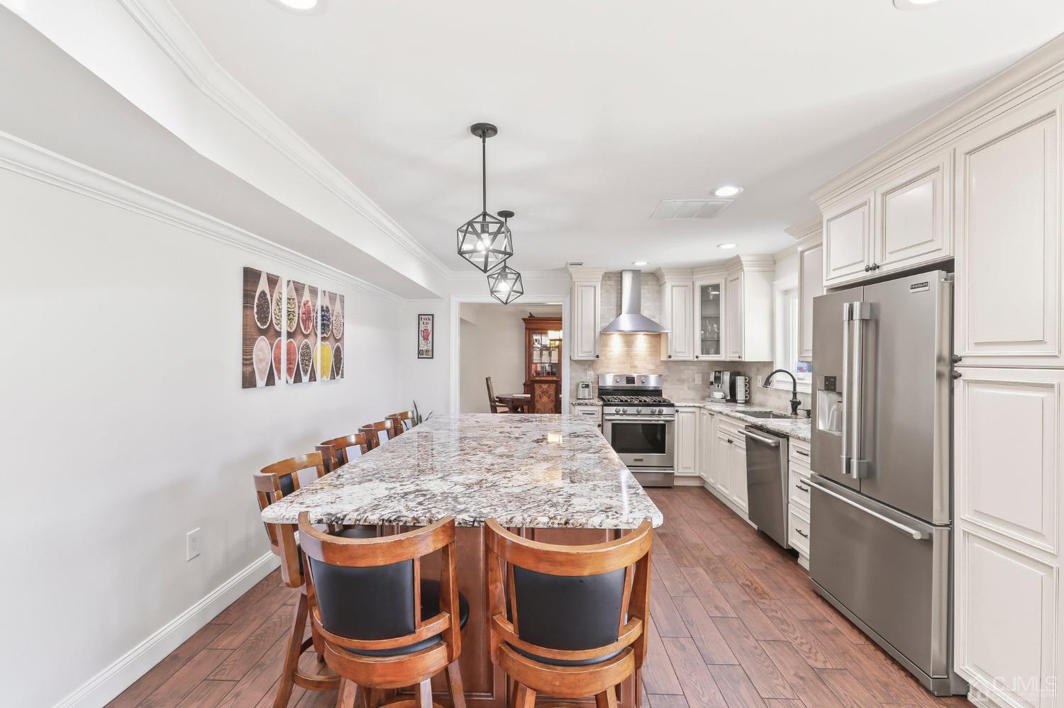 7 Mountbatten Drive Old Bridge, NJ 08857 - Photo 17 of 42 a kitchen with stainless steel appliances granite countertop a dining table chairs refrigerator and cabinets