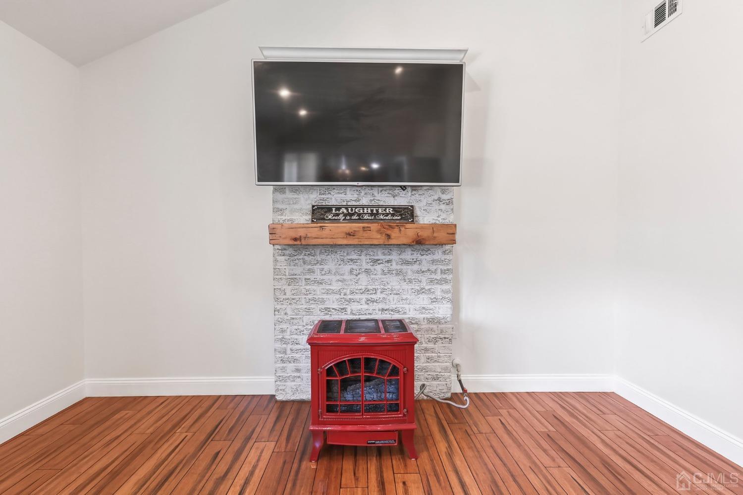 7 Mountbatten Drive Old Bridge, NJ 08857 - Photo 22 of 42 a living room with a fireplace and wooden floor