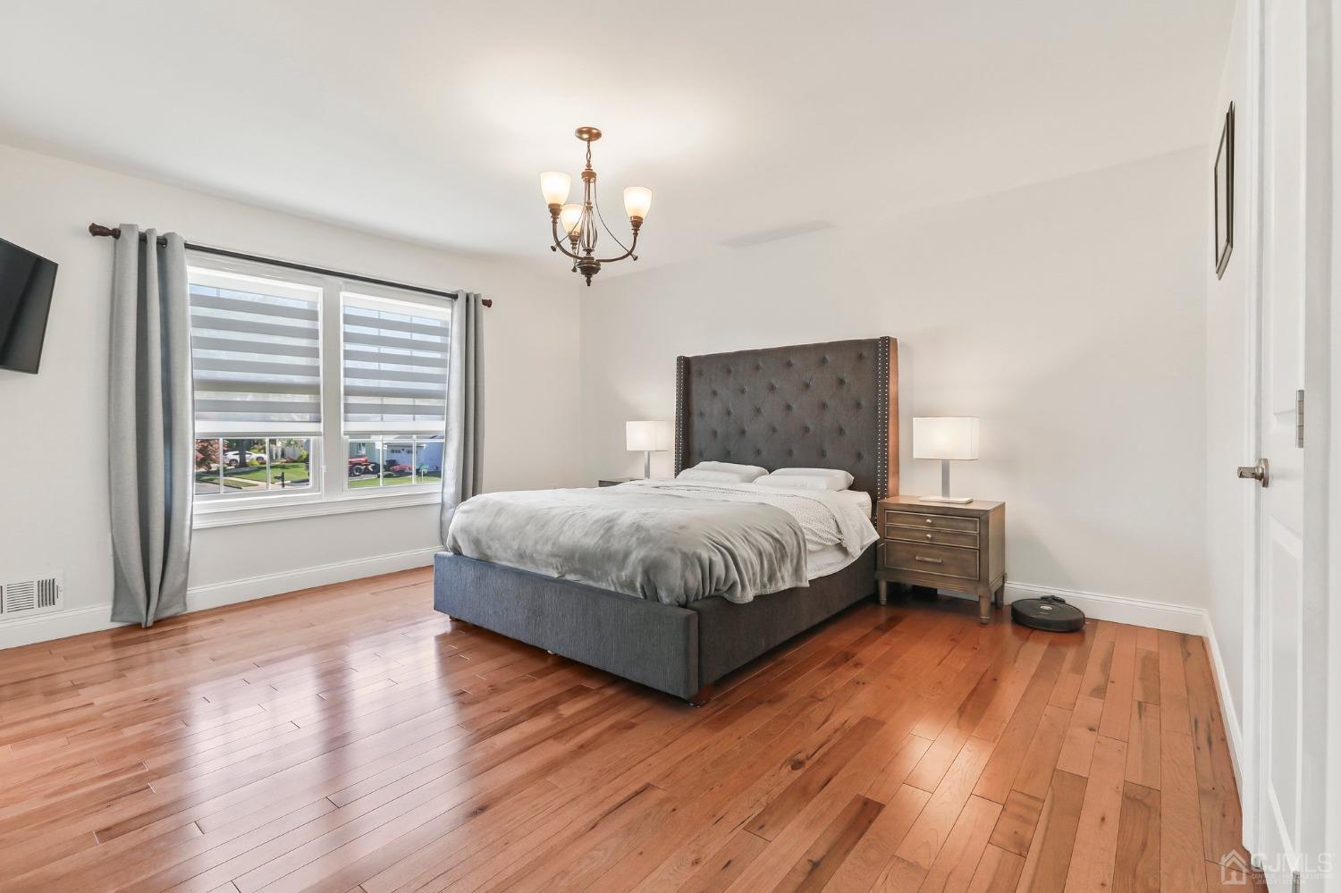 7 Mountbatten Drive Old Bridge, NJ 08857 - Photo 26 of 42 a bedroom with a large bed chandelier and a window