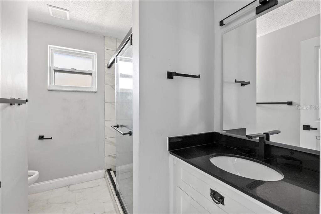 1436 Mardrake Road Daytona Beach, FL 32114 - Photo 14 of 37 a bathroom with a granite countertop sink and a mirror