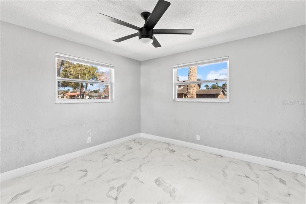 1436 Mardrake Road Daytona Beach, FL 32114 - Photo 16 of 37 a view of a big room with wooden floor and a ceiling fan