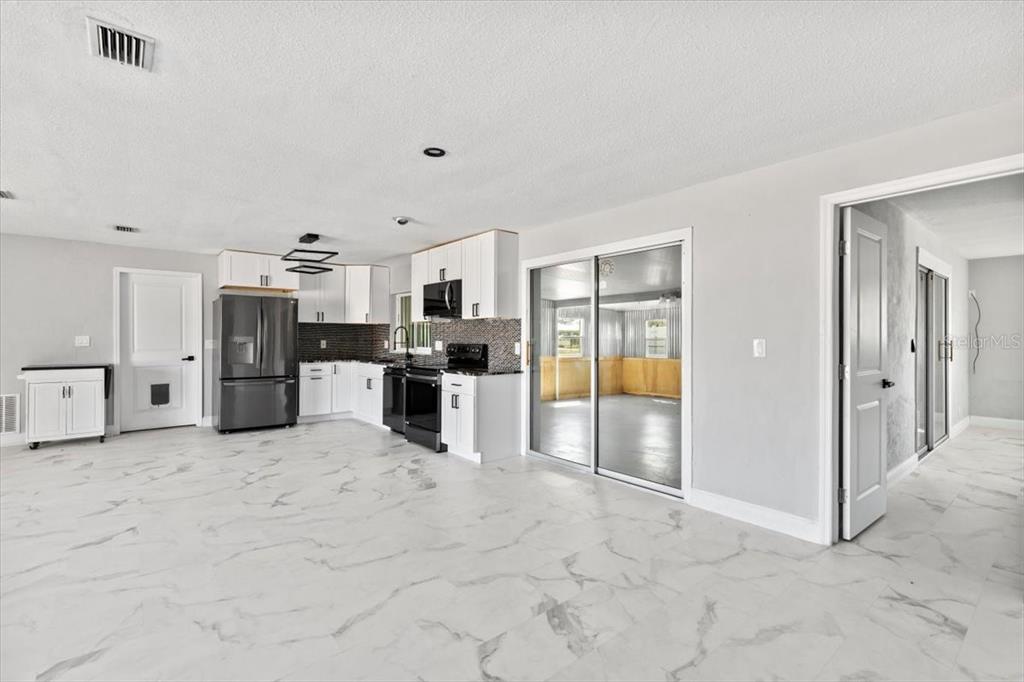 1436 Mardrake Road Daytona Beach, FL 32114 - Photo 18 of 37 a large white kitchen with refrigerator and cabinets