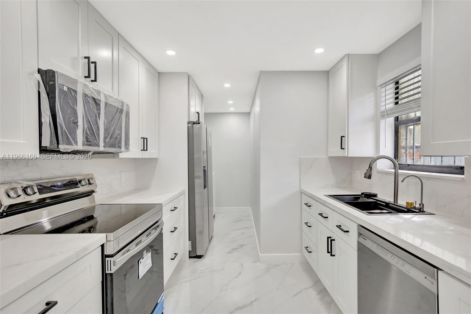 3916 Northwest 207 St Road Miami Gardens, FL 33055 - Photo 3 of 38 a kitchen with stainless steel appliances a refrigerator sink and stove
