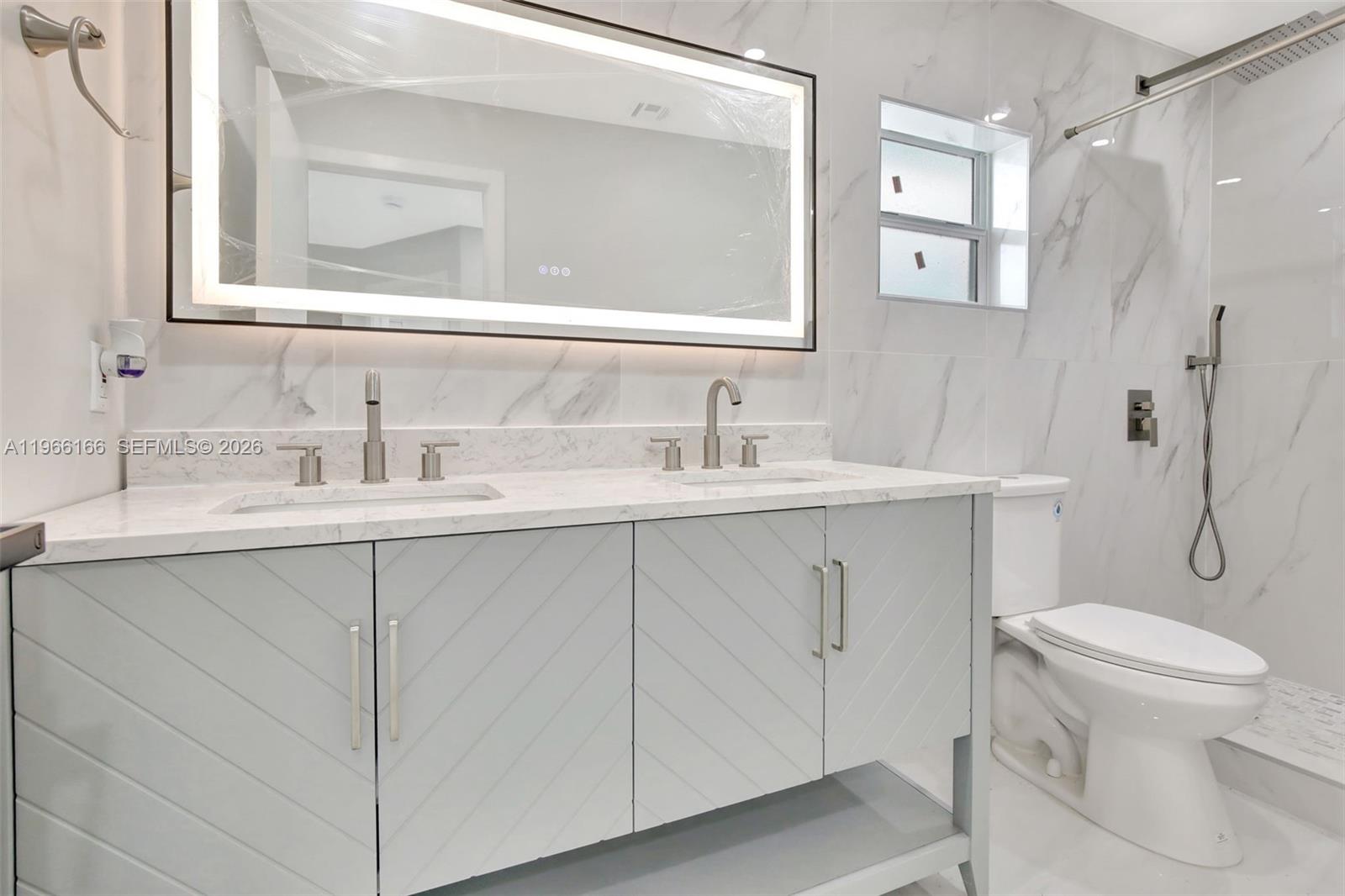 3916 Northwest 207 St Road Miami Gardens, FL 33055 - Photo 6 of 38 a bathroom with a toilet sink and mirror