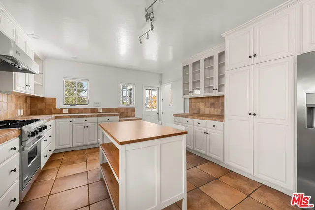 a kitchen with granite countertop white cabinets and stainless steel appliances