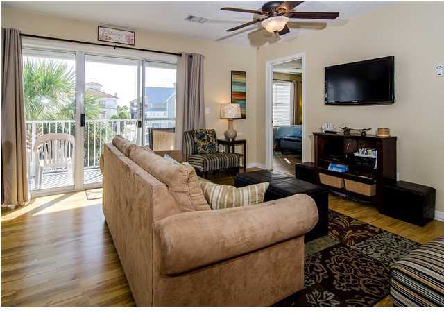 11 Beachside Drive, Unit 1023 Santa Rosa Beach, FL 32459 - Photo 2 of 24 a living room with furniture a flat screen tv and a floor to ceiling window