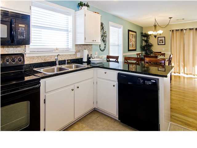 11 Beachside Drive, Unit 1023 Santa Rosa Beach, FL 32459 - Photo 6 of 24 a kitchen with granite countertop white cabinets and black appliances