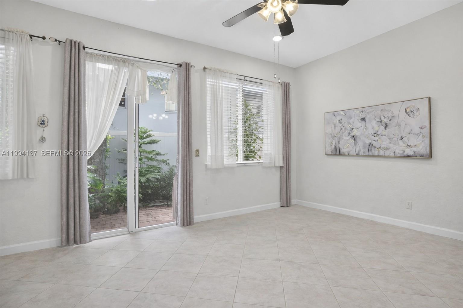 728 Southeast 2nd Street Pompano Beach, FL 33060 - Photo 3 of 27 an empty room with windows and ceiling fan