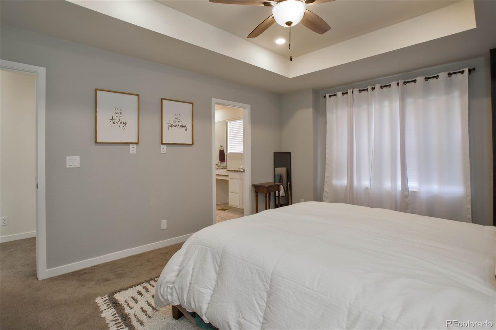 1131 Williams Loop Elizabeth, CO 80107 - Photo 24 of 40 a spacious bedroom with a bed and a chandelier
