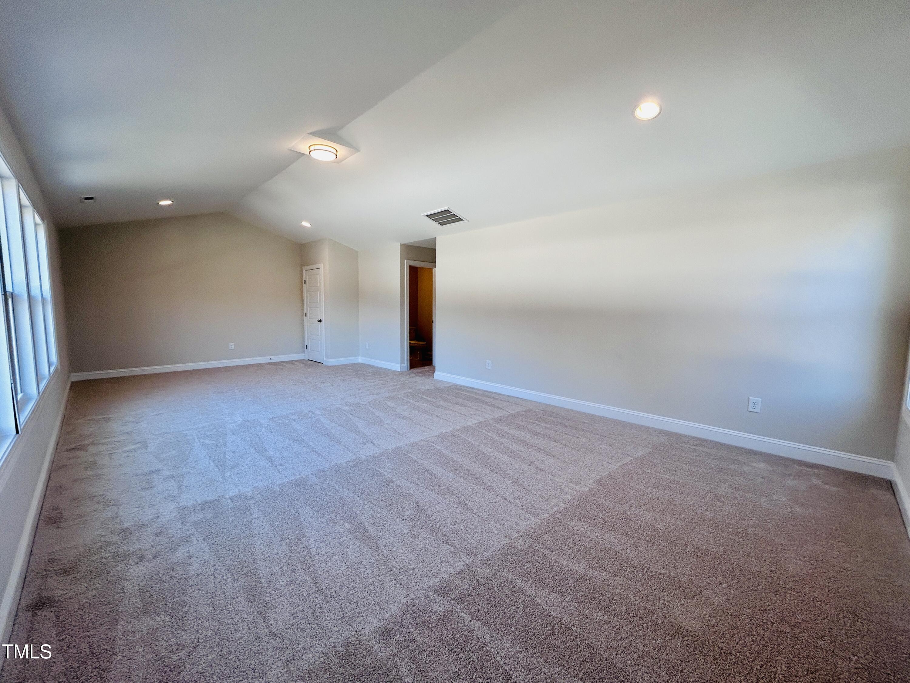 1220 Marsh Hawk Way Wake Forest, NC 27587 - Photo 17 of 23 an empty room with wooden floor and windows