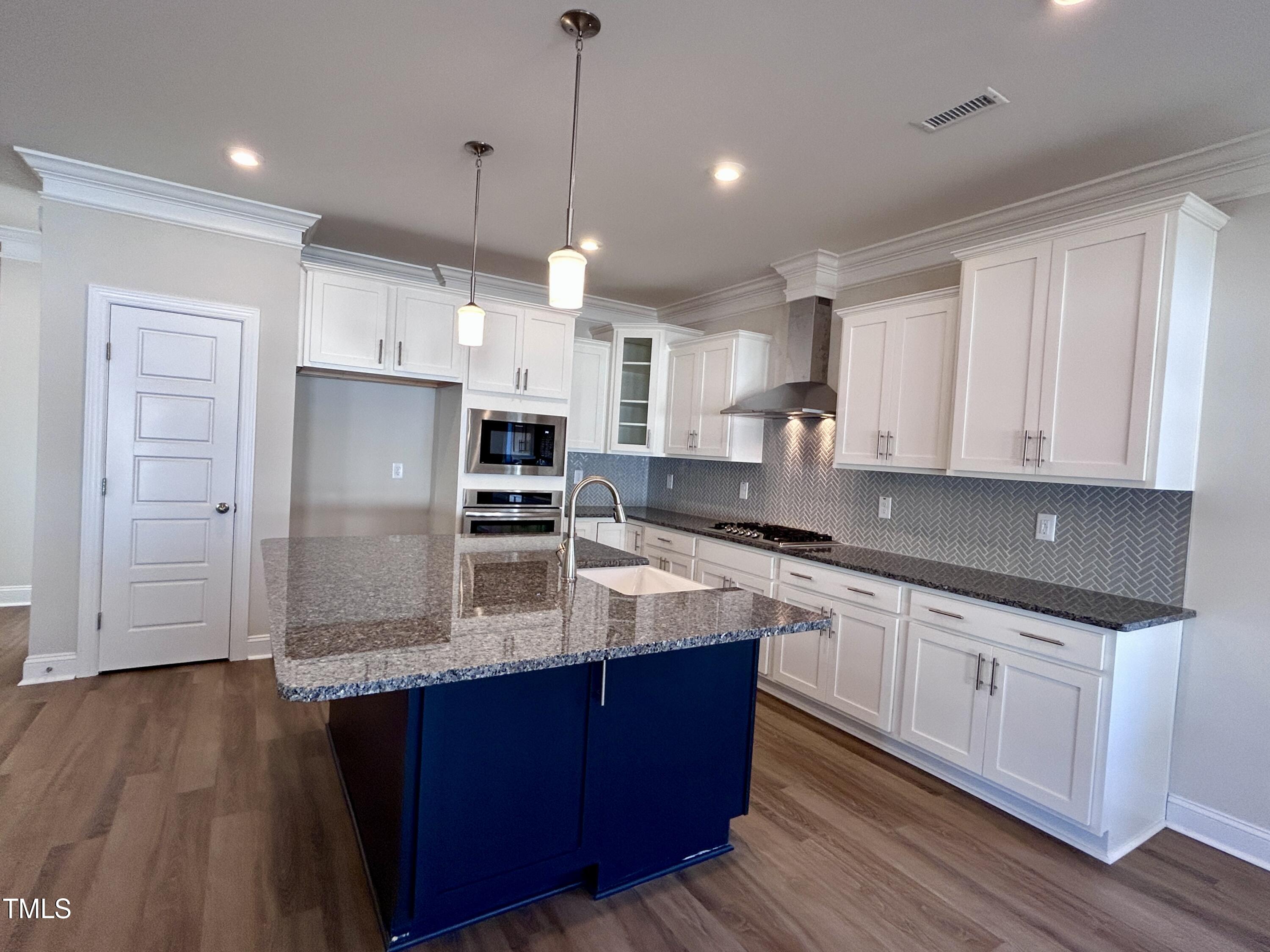 1220 Marsh Hawk Way Wake Forest, NC 27587 - Photo 9 of 23 a large kitchen with stainless steel appliances and wooden cabinets