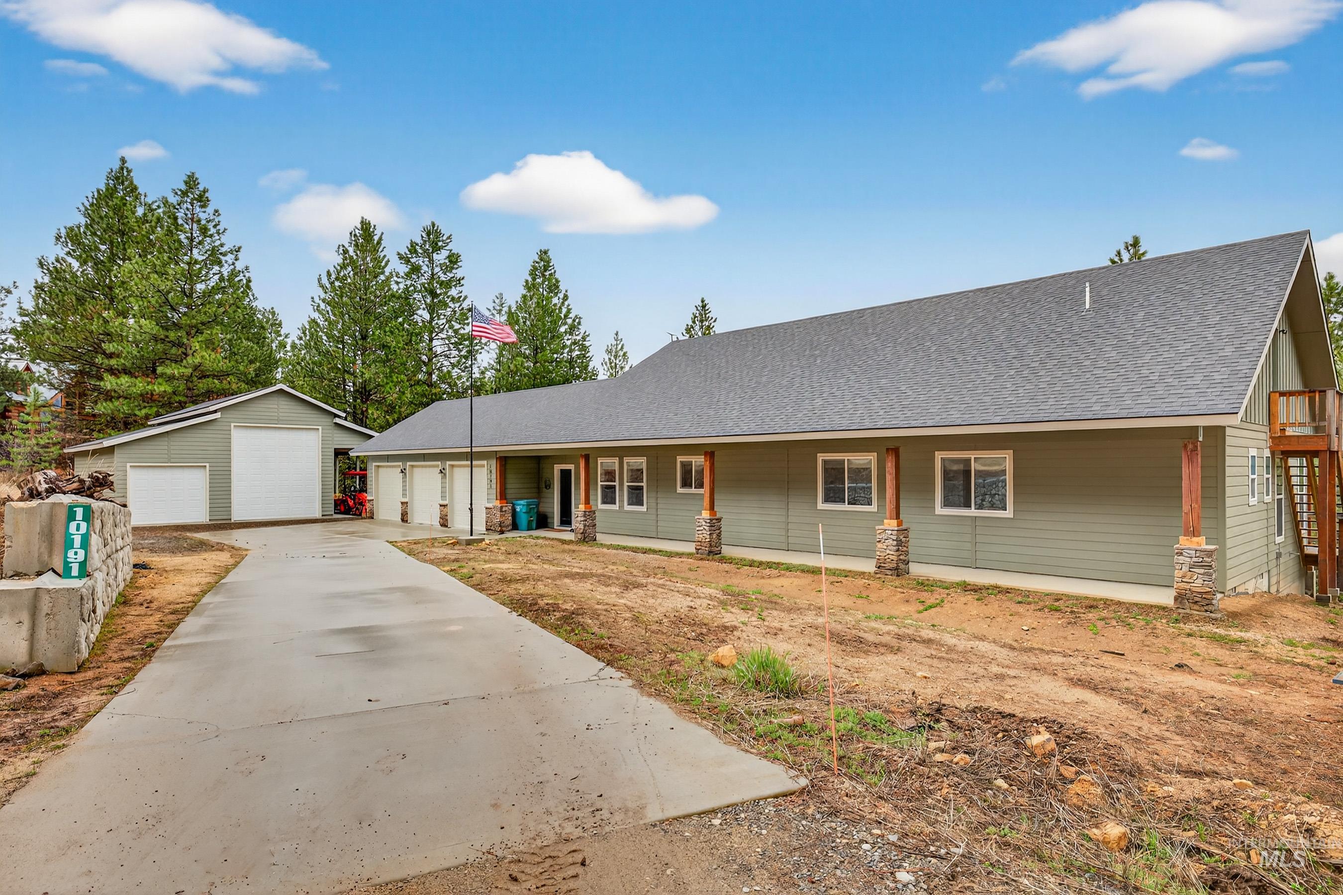10191 Timberrim Drive Cascade, ID 83611 - Photo 4 of 44 View of front of property featuring a shingled roof, an outbuilding, a detached garage, and covered porch