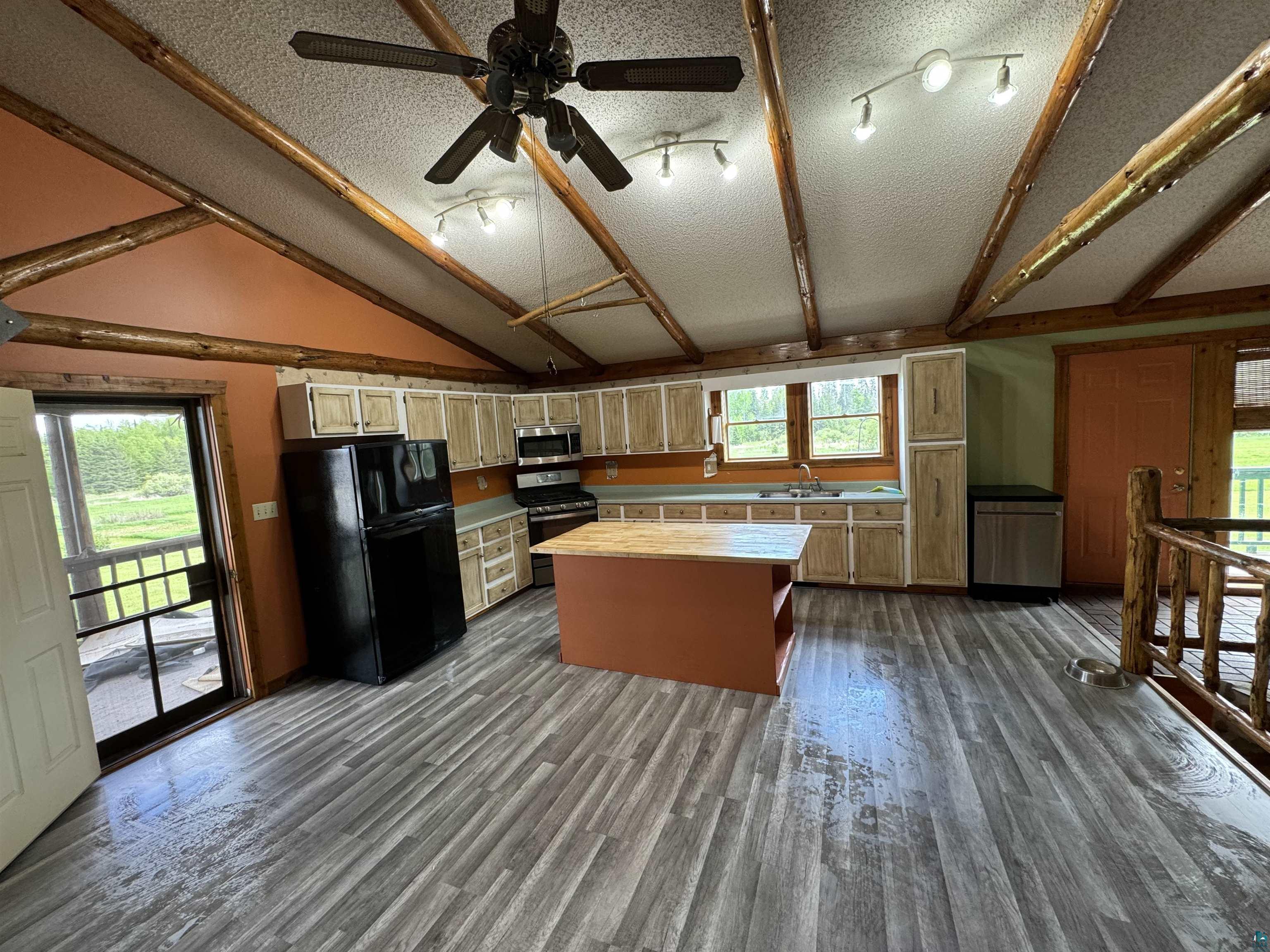 7264 NE Road Wright, MN 55798 - Photo 4 of 17 Kitchen with stainless steel appliances, vaulted ceiling, dark wood-type flooring, and a healthy amount of sunlight