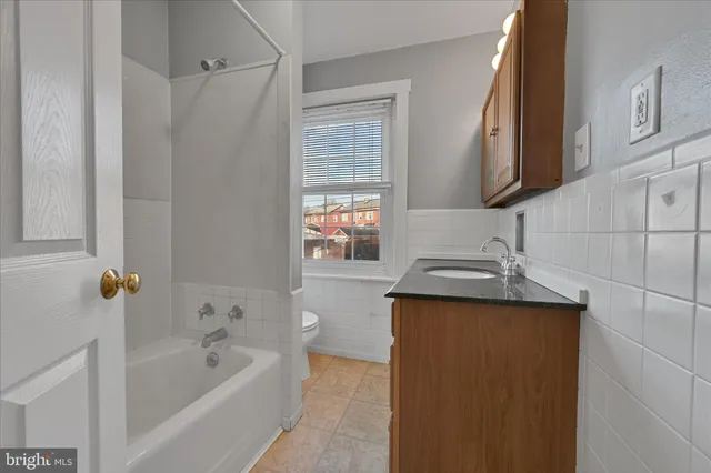 a bathroom with a granite countertop sink a mirror and a bathtub