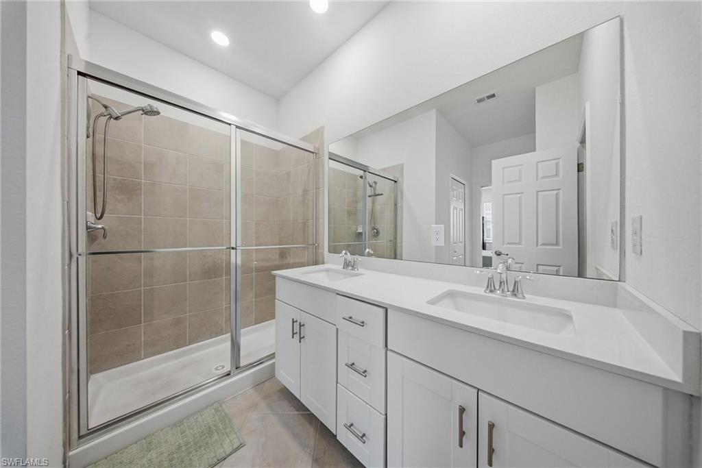2930 Citrus Street Naples, FL 34120 - Photo 24 of 35 a bathroom with a double vanity sink mirror and shower