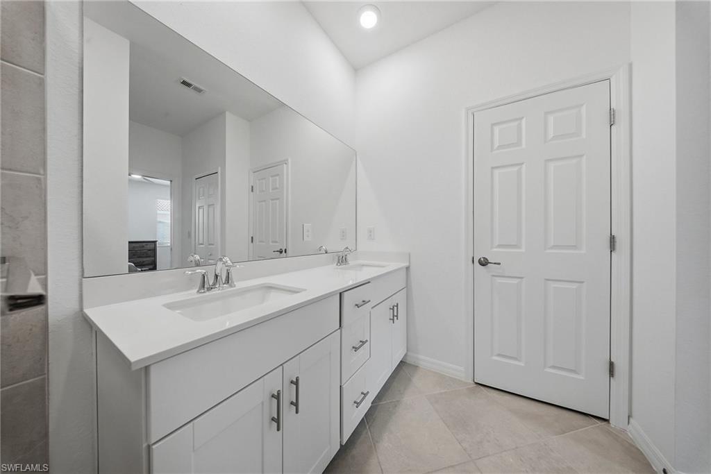 2930 Citrus Street Naples, FL 34120 - Photo 25 of 35 a bathroom with a double vanity sink and mirror