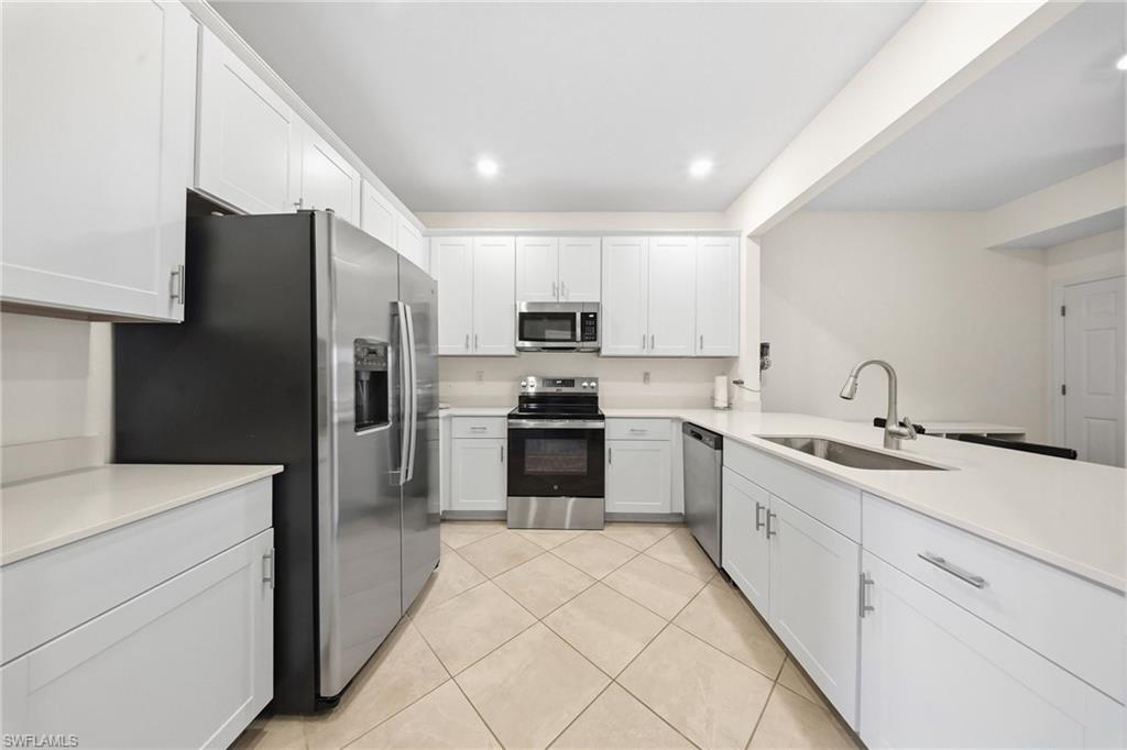 2930 Citrus Street Naples, FL 34120 - Photo 5 of 35 a kitchen with granite countertop white cabinets and stainless steel appliances
