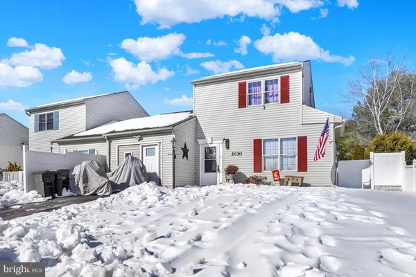 a view of a house with snow on the side of the road