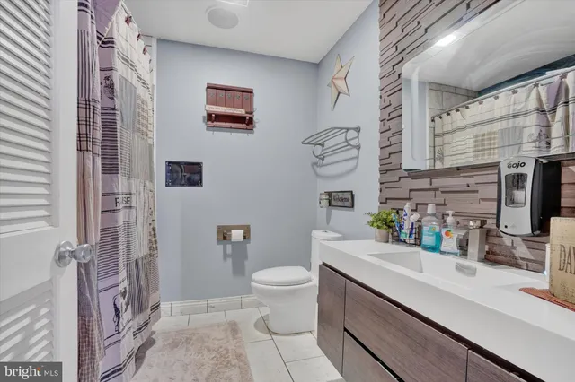 a bathroom with a sink a toilet and shower curtain