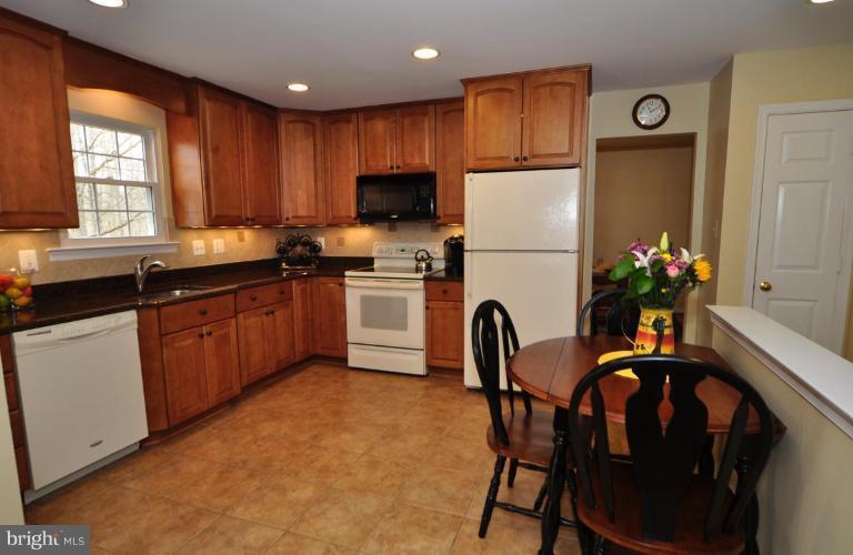 812 Potomac Ridge Court Sterling, VA 20164 - Photo 8 of 30 a kitchen with stainless steel appliances granite countertop a refrigerator a sink a stove and white cabinets