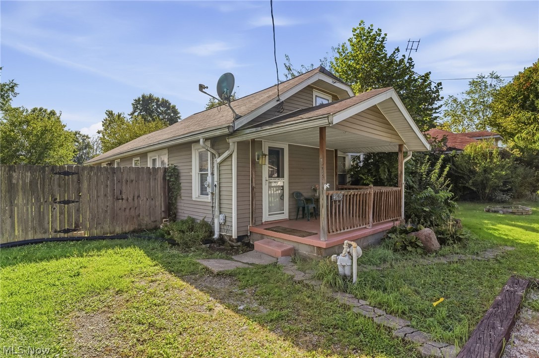 4619 Ridge Avenue Southeast Canton, OH 44707 - Photo 2 of 26 Front porch with wood railing and columns, siding exterior, and a fenced yard