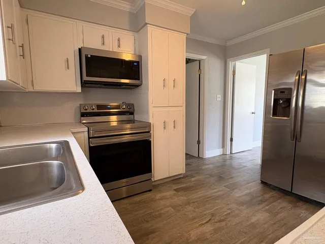 a kitchen with stainless steel appliances granite countertop a refrigerator stove and microwave