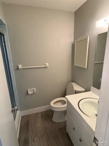 a bathroom with a granite countertop toilet and a sink