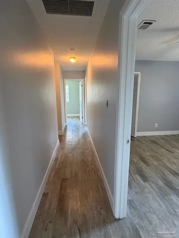 a view of a hallway with wooden floor