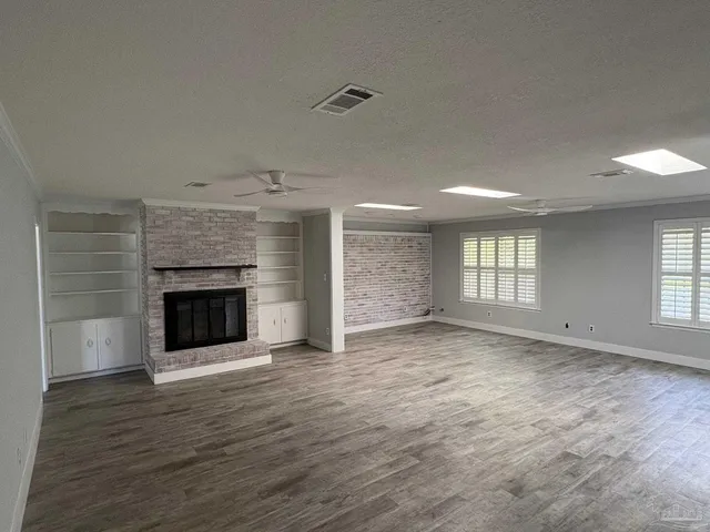 an empty room with windows and fireplace