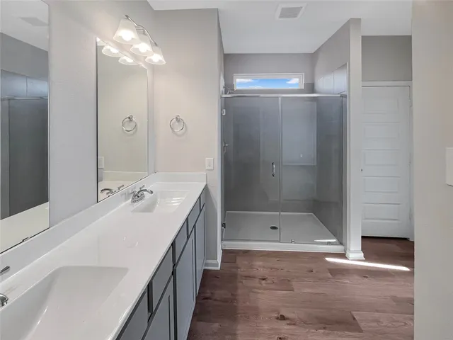 a bathroom with a shower sink and mirror