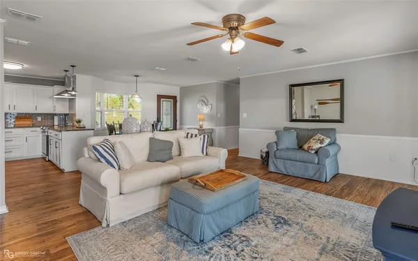 a living room with furniture a ceiling fan and a rug