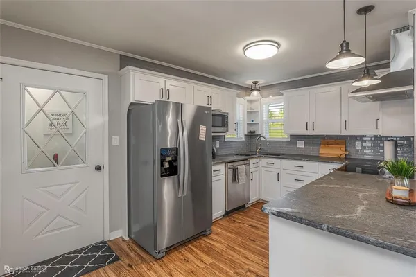 a kitchen with stainless steel appliances granite countertop a refrigerator and a stove top oven