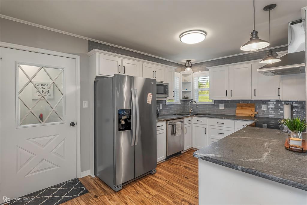 1615 Airport Loop Homer, LA 71040 - Photo 17 of 35 a kitchen with stainless steel appliances granite countertop a refrigerator and a stove top oven