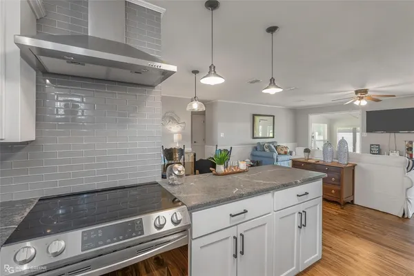 a kitchen with a stove cabinets and wooden floor