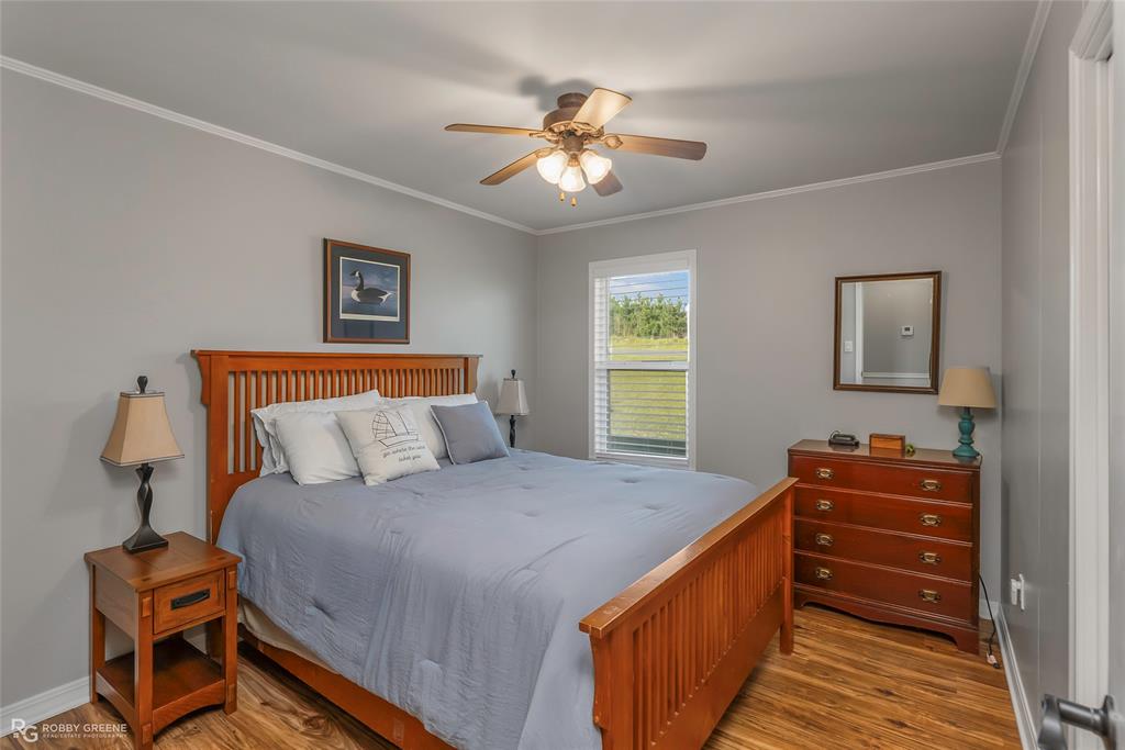 1615 Airport Loop Homer, LA 71040 - Photo 24 of 35 a bedroom with a bed and a chandelier