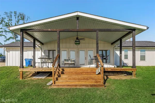 a view of a house with backyard and porch
