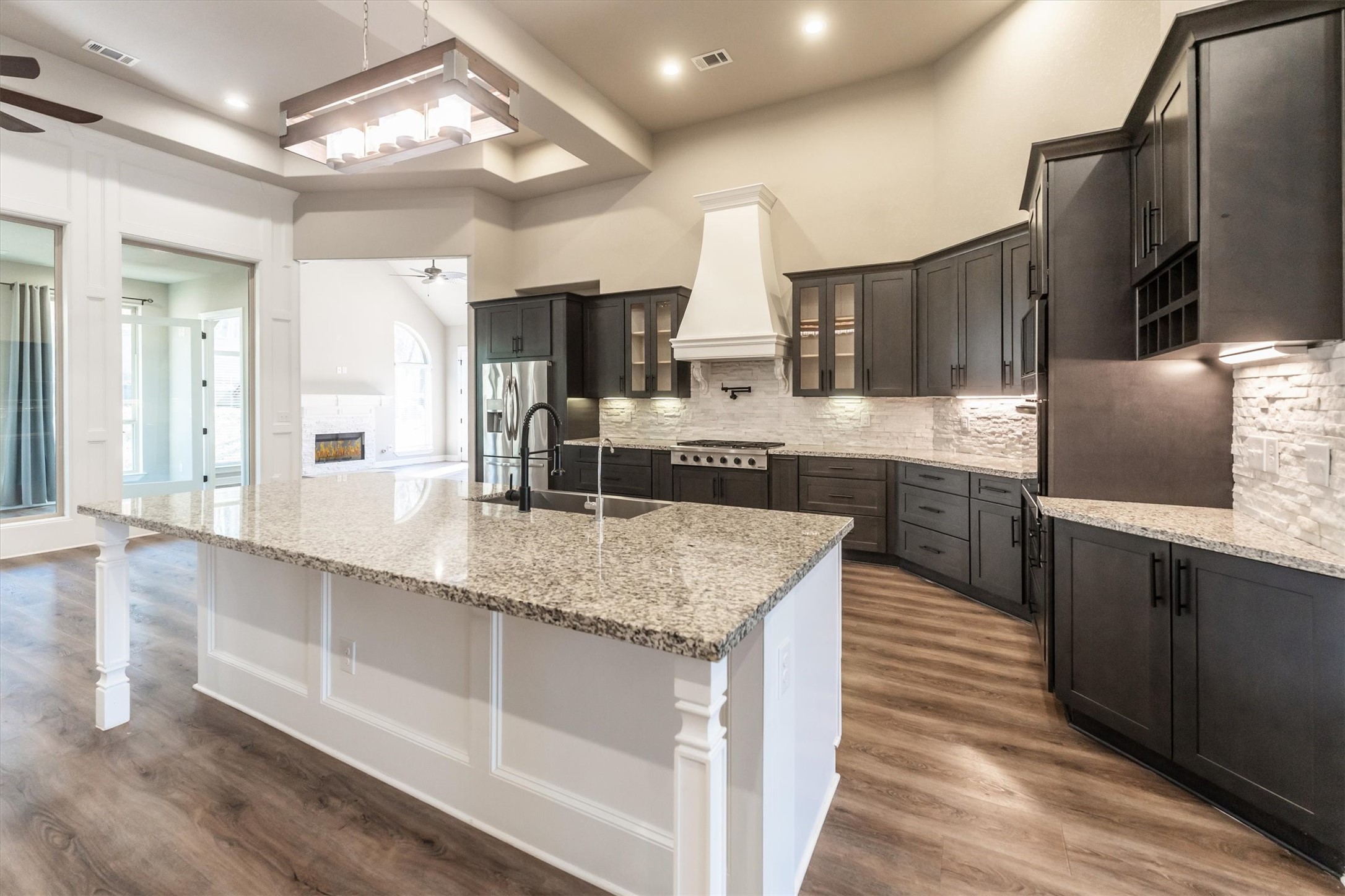 2172 Greentree Drive Huntsville, TX 77340 - Photo 15 of 45 Open kitchen showcasing a functional island, stainless appliances, storage, and vent hood.