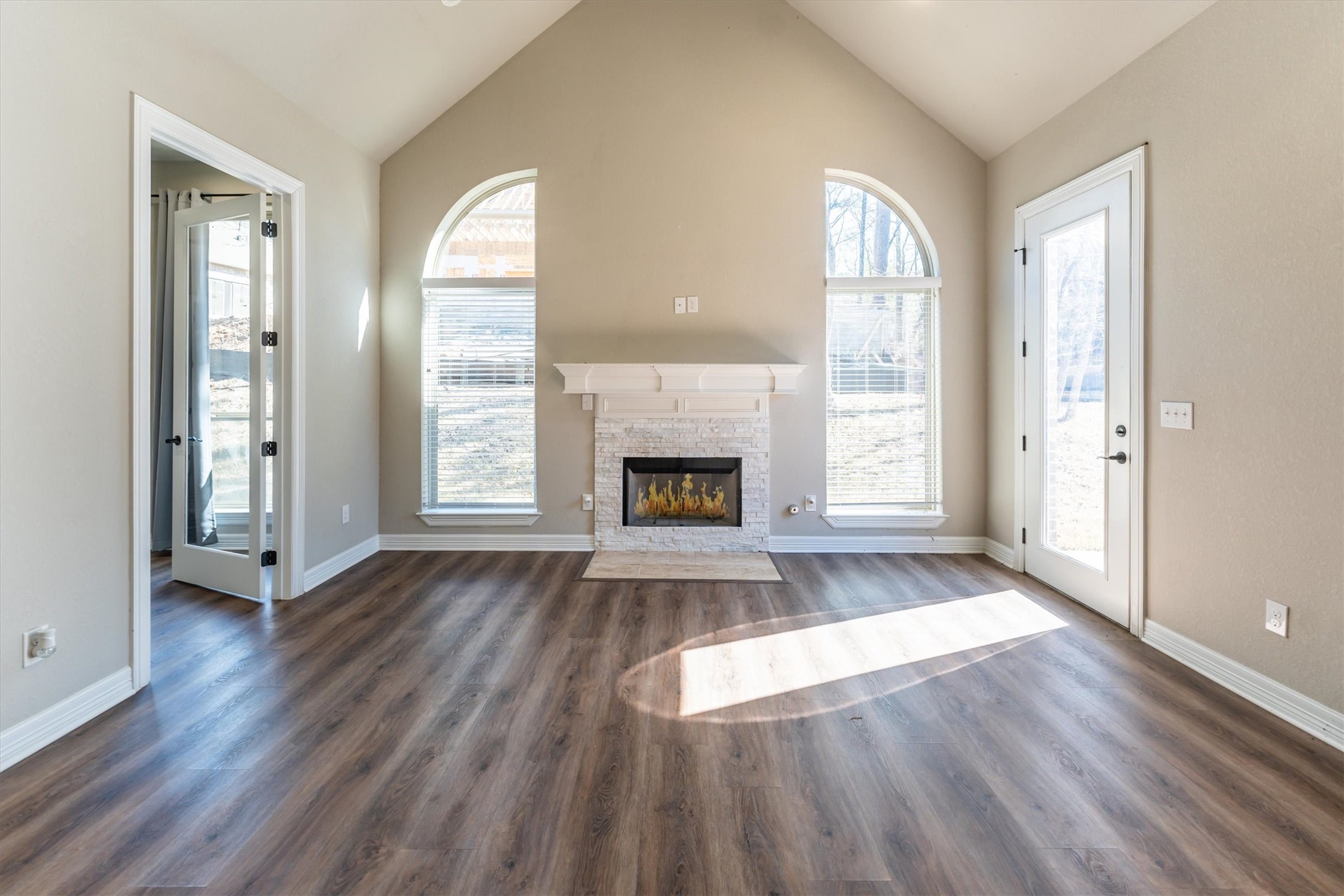 2172 Greentree Drive Huntsville, TX 77340 - Photo 23 of 45 Sophisticated living space featuring a fireplace, sun-drenched windows, and sunroom access.