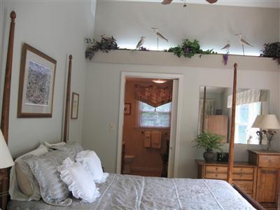 249 Holly Point Road Centerville, MA 02632 - Photo 15 of 20 a bedroom with a bed and a chandelier