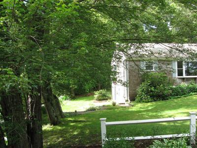 249 Holly Point Road Centerville, MA 02632 - Photo 4 of 20 a view of a white house with a yard and plants