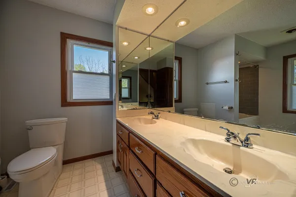 a bathroom with a sink double vanity granite and a toilet