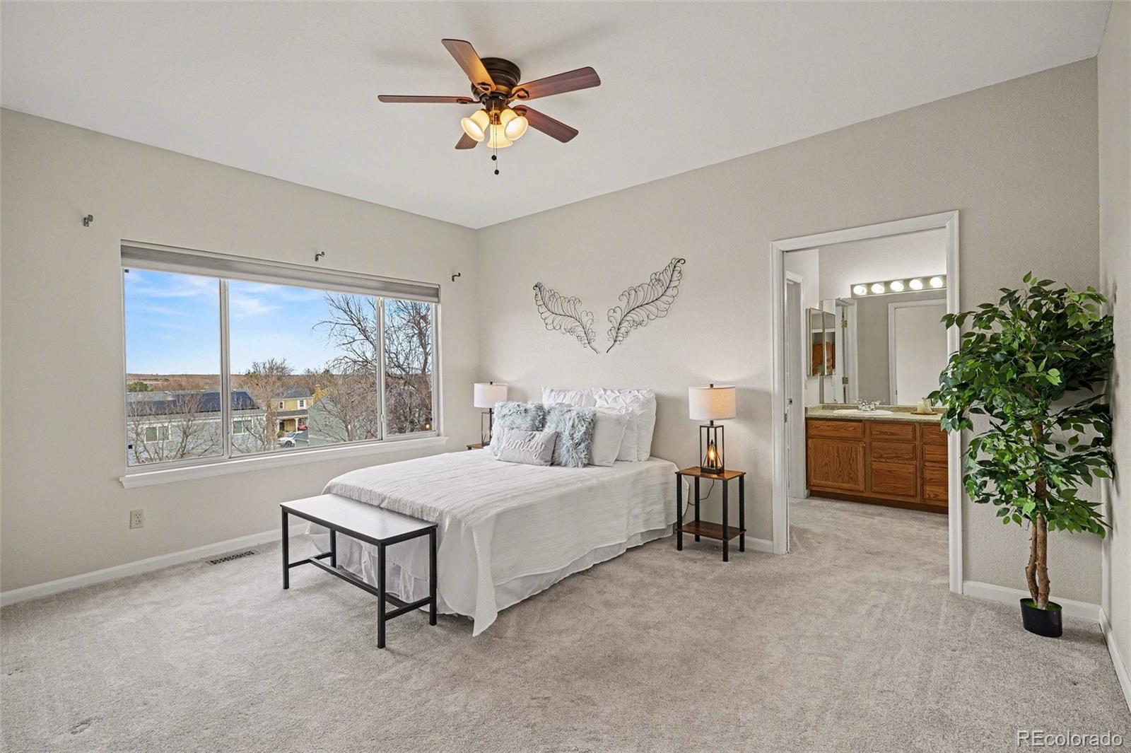 12271 West Chenango Drive Morrison, CO 80465 - Photo 11 of 37 a bed room with a bed and a chandelier