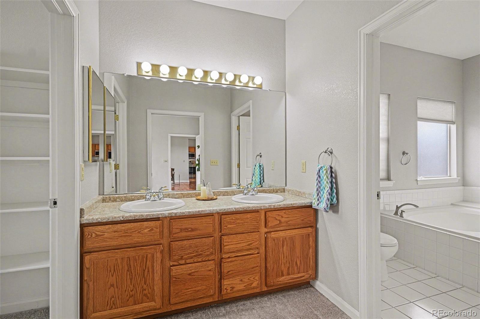 12271 West Chenango Drive Morrison, CO 80465 - Photo 12 of 37 a spacious bathroom with a granite countertop sink a mirror and a